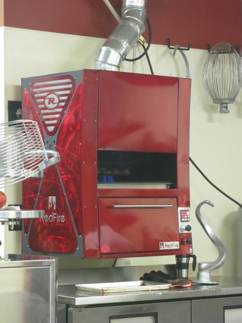The wing-baking contraption.  You can see the wings, and the fire.  Also, the massive dough hook sitting on the counter--used for mixing up the crust.