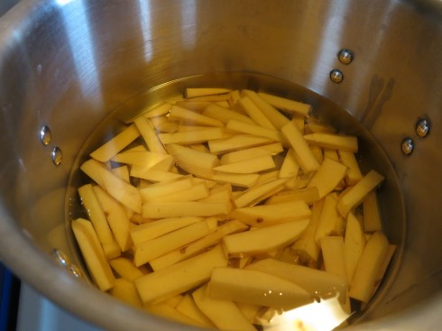 Potatoes chopped and covered in room temperature oil.
