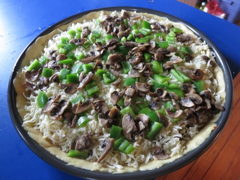 Mushrooms and green pepper on top of the cheese, sausage underneath.